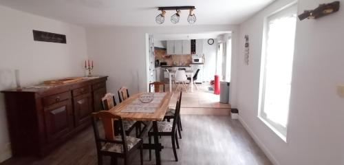 a kitchen and dining room with a table and chairs at Grande maison au charme chaleureux hiver comme été in La Bourboule