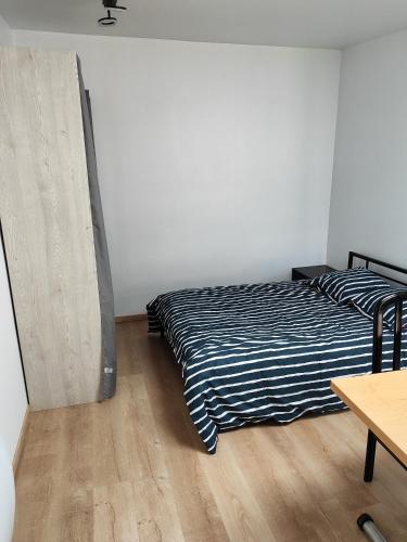 um quarto com uma cama e piso em madeira em studio independant avec jardin au calme em Neuilly-Plaisance