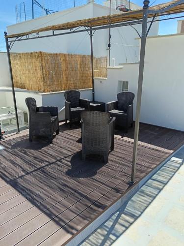 a patio with chairs and tables on a deck at La Finestra su Santa Lucia in Monopoli