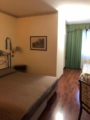 a bedroom with a bed and a green curtain at Villa Felcaro - Relais, Lodge & Restaurant in Cormòns