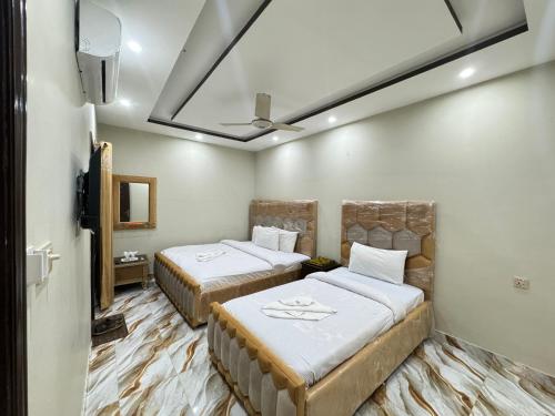 Habitación con 2 camas y ventilador de techo. en Decent Lodge Guest House F-10, en Islamabad