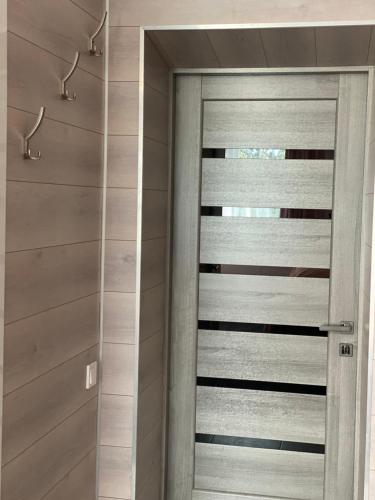 a pivot door in a bathroom with wooden walls at Hotel TETRIS Voznesensk in Voznesensk