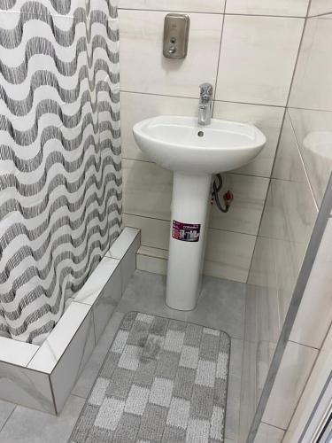 a bathroom with a sink and a shower curtain at Hotel TETRIS Voznesensk in Voznesensk