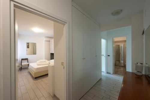 um quarto branco com um quarto e uma cama em Holiday Apartments Bellariva em Riva del Garda