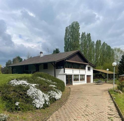 a large white house with a brick driveway at Appartement Le Domaine du Cygne in Barst-Marienthal