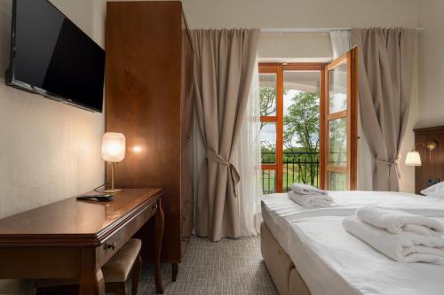 a hotel room with two beds and a desk and a window at Boutique Hotel Paradiso in Poreč