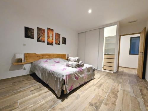 une chambre avec un lit et un parquet dans l'établissement Villa au cœur des Landes, à Soustons