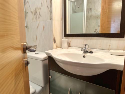 a bathroom with a sink and a toilet and a mirror at El Patuco - 6821 in Noja