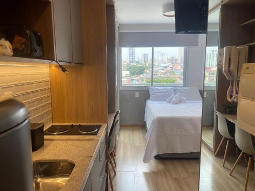 - une petite cuisine avec un lit dans une chambre dans l'établissement Noamar Pituba, à Salvador
