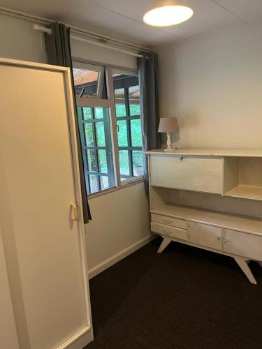 an empty room with a desk and a window at huisje in het bos in Zuidlaren