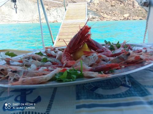 a plate of seafood on a table next to the water at La dimora degli scrittori in Porto Empedocle