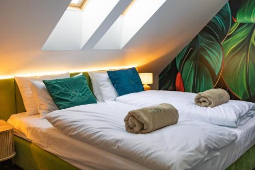 a bedroom with a bed with towels on it at Boulevard Boutique Suites in Łeba