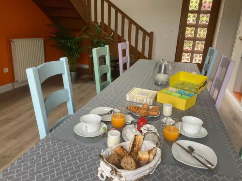 a table with a breakfast of bread and orange juice at LA PASSIFLORE in Azé