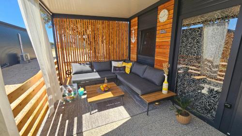 eine abgeschirmte Veranda mit einem Sofa und einem Tisch in der Unterkunft CHARTA mobile home Bimbo in Pirovac