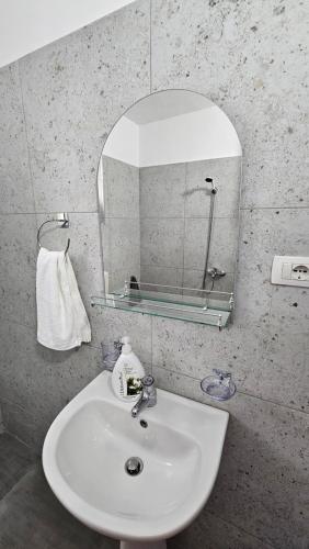 a bathroom with a sink and a mirror at Aliaj's Guest House in Berat