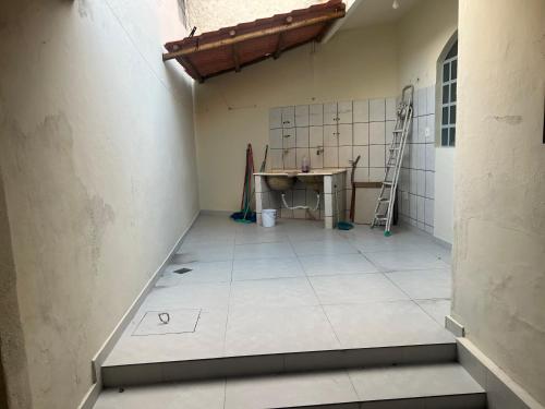 a bathroom with a sink and a tiled floor at Casa 400m do shopping in Governador Valadares