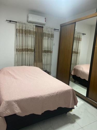a bedroom with a pink bed and a mirror at Casa 400m do shopping in Governador Valadares
