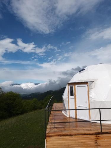 a yurt on a wooden deck with a view of the mountains at Dilijan Glamping in Dilijan