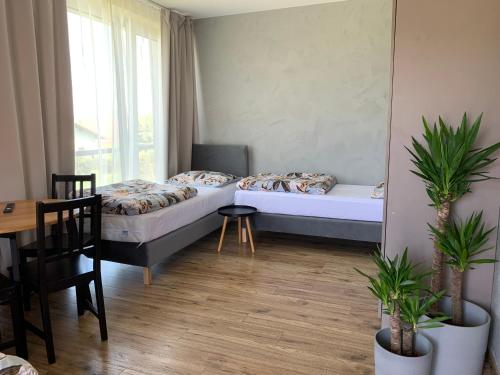 Habitación pequeña con 2 camas, mesa y mesa en Apartamenty Nad Zimnikiem, en Lipowa