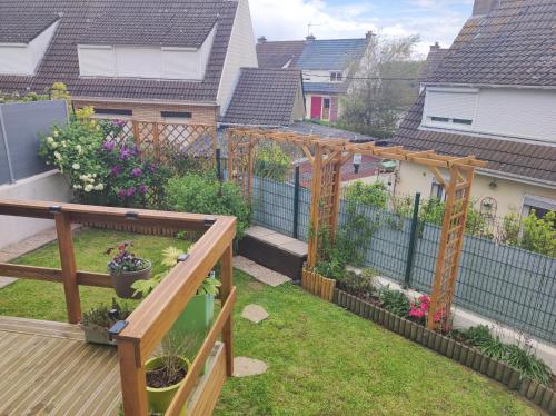 einen Hinterhof mit einer Pergola und einem Garten in der Unterkunft CHEZ ISA Maison à 2 km de la plage de Le Portel 62 in Outreau