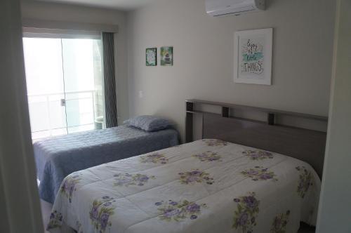 a bedroom with two beds and a window at AP Praia do Forte! Charme e conforto!(104) in Cabo Frio