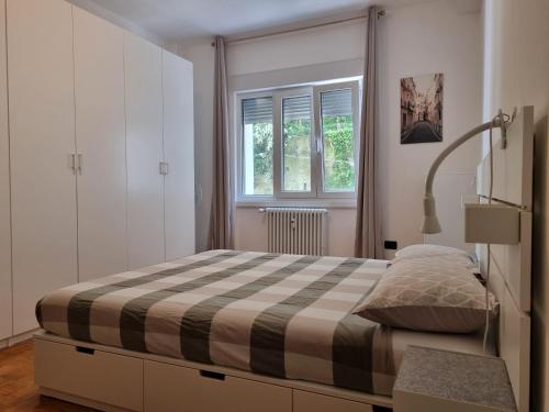 una camera da letto con un letto e una finestra di Apt by Trieste University a Trieste