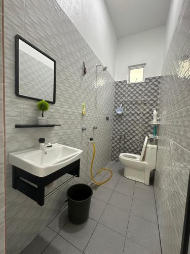 a bathroom with a sink and a toilet at Tokmabah Homestay in Ketereh