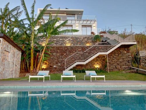 a villa with a swimming pool and a house at Villa Amendoa in Arco da Calheta