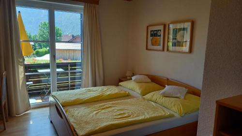 - 2 lits dans une chambre avec fenêtre dans l'établissement Ferienwohnungen Haus Peer, à Bad Goisern