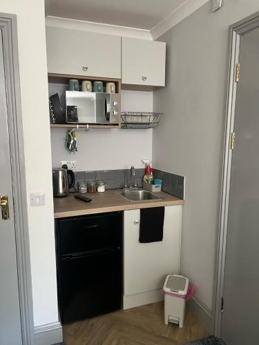 eine kleine Küche mit einer Spüle und einer Theke in der Unterkunft Highmead House in Camelford