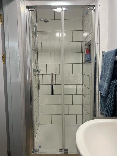 W łazience znajduje się szklana kabina prysznicowa i umywalka. w obiekcie Highmead House w mieście Camelford