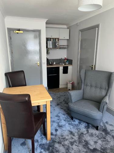 ein Wohnzimmer mit einem Tisch und Stühlen sowie eine Küche in der Unterkunft Highmead House in Camelford