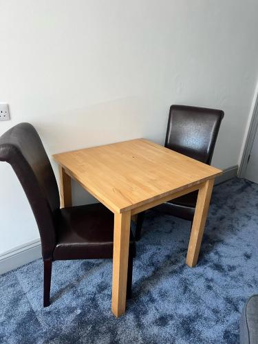 a wooden table and two chairs in a room at Highmead House in Camelford