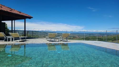 a swimming pool with chairs and a view of the mountains at Casa Castella - Adults Only - Langhe in Diano dʼAlba