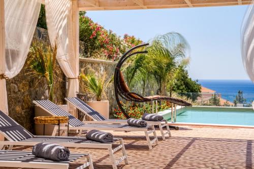um pátio com cadeiras e uma piscina em Heliophos Villa Aelia em Kiotari