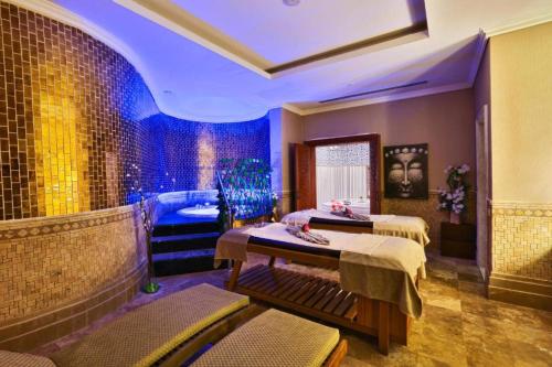 沙姆沙伊赫的住宿－Hotel Makadi sharm elshekh，客房设有两张床和蓝色灯光浴缸。