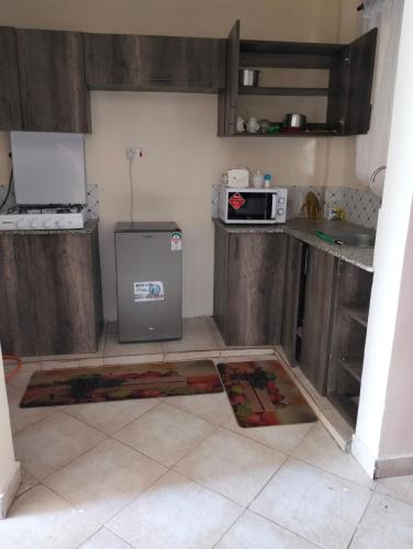 a kitchen with a refrigerator and a counter top at Yala comfy homes in Kitengela 