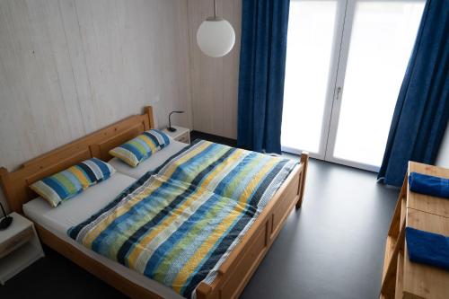 ギュンツブルクにあるGästewohnung in Massivholzhausのベッドルーム1室(カラフルな掛け布団と枕付きのベッド1台付)