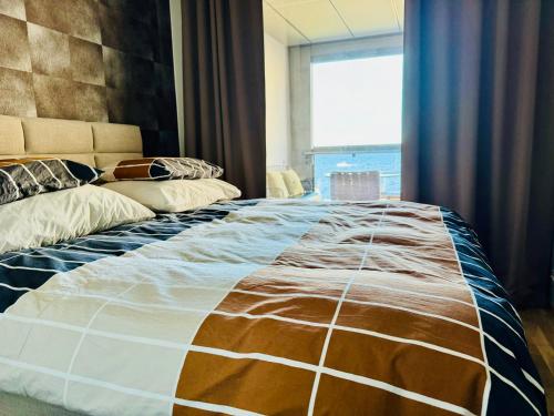 a large bed in a room with a large window at Top, cozy, lakeside, sauna and free indoor parking in Tampere