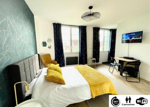 ein Schlafzimmer mit einem Bett mit einer gelben Decke darauf in der Unterkunft Le Panoramique - Centre-ville in Melun