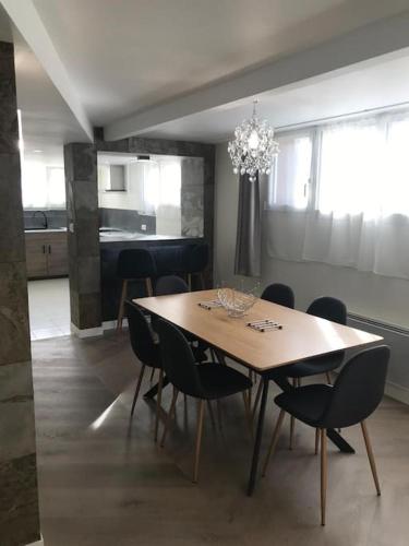 une table à manger avec des chaises et un lustre dans l'établissement Plain-pied 80 m2 dans maison, parking privé gratuit, gare directe Paris, à Versailles