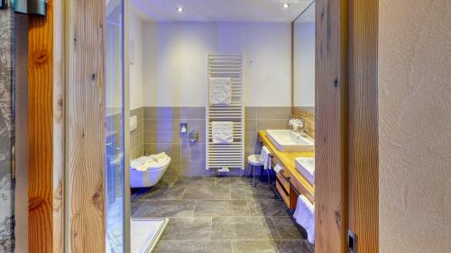 a bathroom with two sinks and a tub and a toilet at Dein Engel in Oberstaufen
