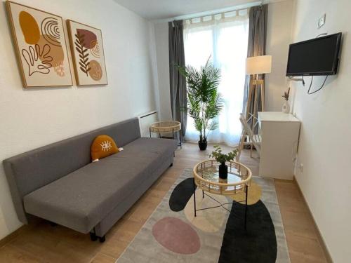 Appartement 2 chambres avec cuisine Gare في غرونوبل: غرفة معيشة مع أريكة وطاولة