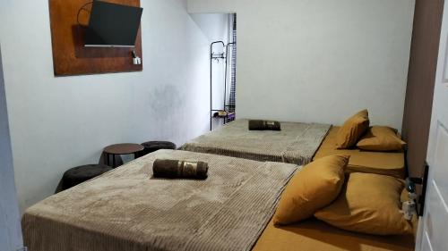 twee bedden in een kamer met een tv aan de muur bij Resy home syariah family room dekat alun2 wonosobo in Kalianget