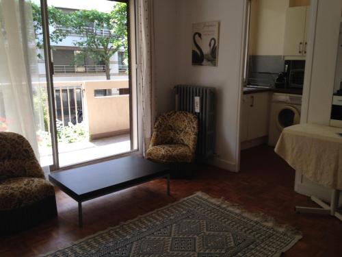 d'un salon avec une porte s'ouvrant sur un balcon. dans l'établissement Boulogne Issy Soleil, à Boulogne-Billancourt