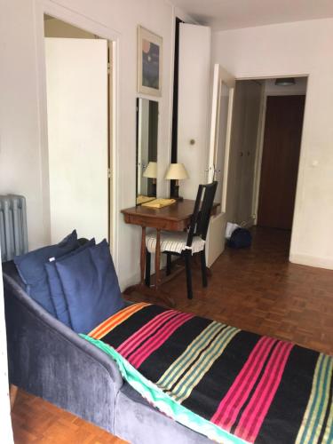 un salon avec un canapé et un bureau dans l'établissement Boulogne Issy Soleil, à Boulogne-Billancourt