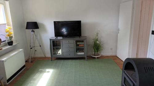 a living room with a flat screen tv on a dresser at Ferienhaus Hansühn "gerne mit Hund" in Hansühn