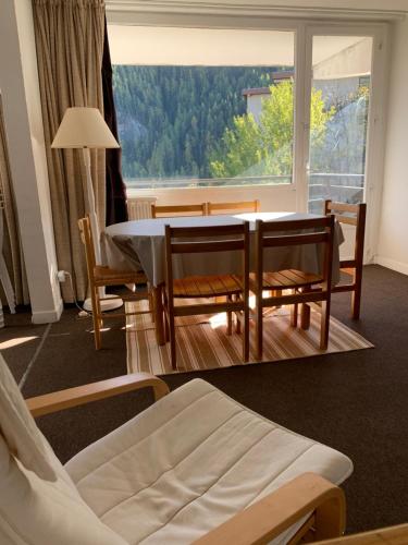 une salle à manger avec une table et des chaises et une grande fenêtre dans l'établissement Appartement proximité immédiate des pistes, à Uvernet