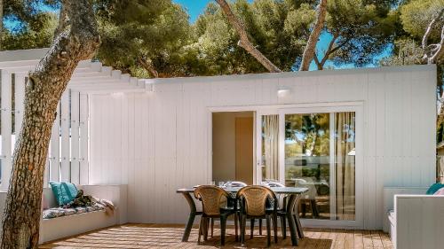 einen Tisch und Stühle auf einer Terrasse mit einem Baum in der Unterkunft Camping Relax Sol in Torredembarra