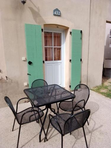 een tafel en stoelen voor een gebouw bij La villa De Lina 431 -Self Check In - in Gallargues-Le-Montueux